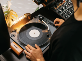 Someone putting a record onto the Lenco L-3810 turntable